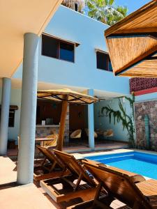 ein Resort mit einem Pool und Stühlen neben einem Gebäude in der Unterkunft Rosarito Hotel in Loreto