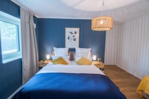 une chambre bleue avec un grand lit et un lustre dans l'établissement Hygge Homes - 3 Zimmer Apartment, barrierefrei mit Terrasse, à Scharmbeck