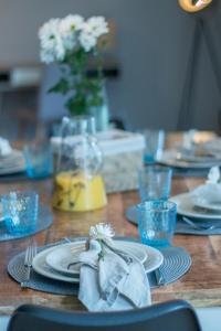 a wooden table with plates and glasses and a napkin at Hygge Homes - 3 Zimmer Apartment, barrierefrei mit Terrasse in Scharmbeck