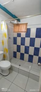 uma casa de banho com um WC e uma cortina de chuveiro em xadrez. em Hostal Cabañas Don Jorge em Puerto Baquerizo Moreno