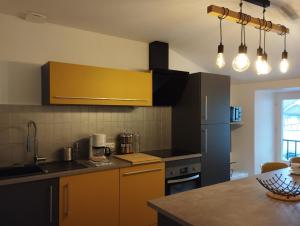 een keuken met gele kasten en een aanrecht bij Pavatou in Aurillac