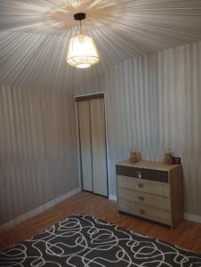 een kamer met een bed, een dressoir en een plafond bij Pavatou in Aurillac