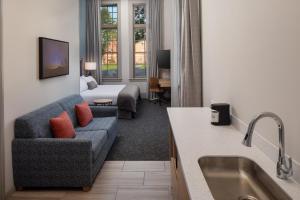 a living room with a couch and a bed at Hotel Ursa in Orono