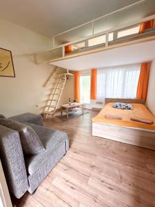 um quarto com uma cama e um sofá em Lakeside Apartmanház Soltvadkert em Soltvadkert