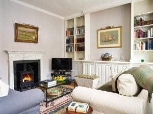 uma sala de estar com um sofá e uma lareira em Northfield End Cottage em Henley on Thames