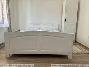 a white bed in a room with a door at Kiadó apartman in Borsec +5 photos