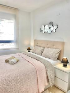 ビリャホヨサにあるApartamento Familiarのベッドルーム1室(ピンクの毛布と鏡付きのベッド1台付)
