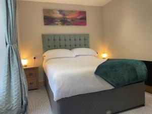 um quarto com uma cama grande e uma cabeceira verde em The Mews 2 bedroom with private parking em Oban