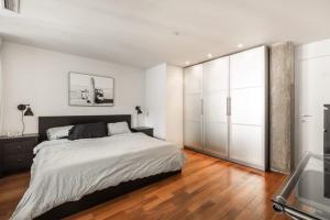 Un dormitorio blanco con una cama grande y una ventana de cristal en Elegant apartment Vieux Port Montreal, en Montreal
