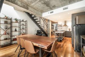 a dining room with a wooden table and a staircase at Elegant apartment Vieux Port Montreal in Montréal