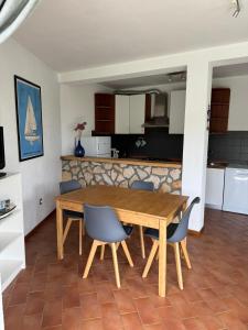 ein Esszimmer und eine Küche mit einem Holztisch und Stühlen in der Unterkunft Apartament Sanja Novigrad in Dajla