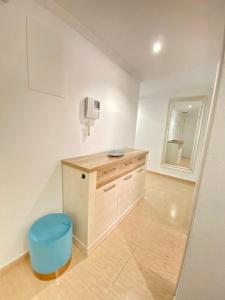 a bathroom with a counter and a blue stool at Apartamento Familiar in Villajoyosa