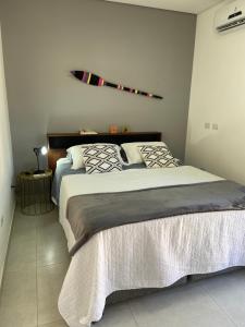 une chambre avec deux lits et une planche de surf au mur dans l'établissement Casa Climatizada-2km centro Histórico, à Parati 35 autres photos