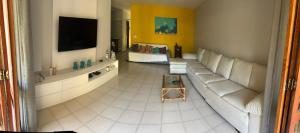un soggiorno con divano e TV di Condominio Via Del Mare a Búzios