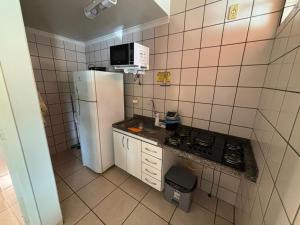 カルダス・ノバスにあるDi Roma Fiori 267 Ap com cozinhaの冷蔵庫と電子レンジを備えた小さなキッチン