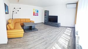 Relax apartmán Pod Javorem في كلادنو: غرفة معيشة بها أريكة وتلفزيون