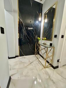 Golden Luxury Suite في نوفي دفور مازوفييتسكي: حمام به دش من الرخام مع طاولة