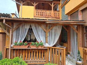 a house with a balcony with flowers on it at Kismarosi Center Apartman in Kismaros