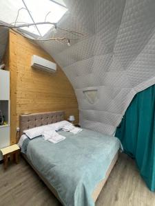Schlafzimmer mit einem großen Bett und einer Decke in der Unterkunft Glamping Machakhela in Ch'ik'unet'i