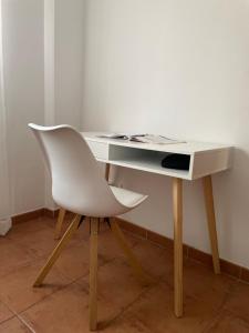 una scrivania bianca con una sedia bianca seduta ad essa di Lovely family house by the golf course a Huelva