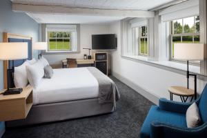 une chambre d'hôtel avec un lit et une chaise dans l'établissement Hotel Ursa, à Orono