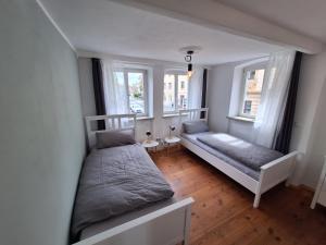 a bedroom with two beds and two windows at Ferienhaus Altstadt in Bamberg
