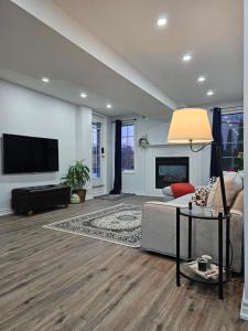 a living room with a couch and a tv at Poolside entire lower level apt in Whitby