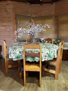蒙特沃德的住宿－Casa Recanto Beija Flor, Monte Verde，餐桌、椅子和花瓶