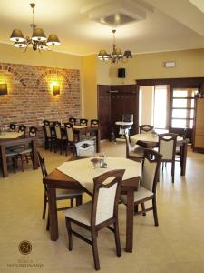 a restaurant with tables and chairs and a brick wall at Hotel Nekla in Nekla