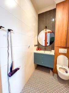 a bathroom with a toilet and a mirror at Gdansk Central Apartment in Gdańsk
