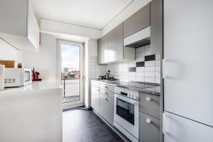 eine Küche mit weißen Geräten und einem großen Fenster in der Unterkunft Cooldis 4 !Gratis Parken, Free Parking! in Kreuzlingen