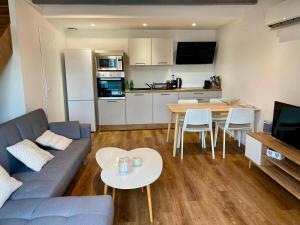 ein Wohnzimmer mit einem Sofa und einem Tisch sowie eine Küche in der Unterkunft Duplex 1 chambre in Chalamont