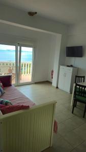 1 dormitorio con cama y vistas al océano en Syvota Sunset Apartments, en Perdika