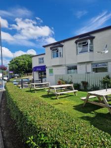 una fila di tavoli da picnic di fronte a un edificio di Arnolds Hotel a Dunfanaghy