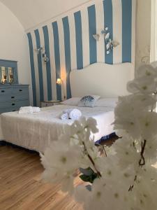 1 dormitorio con 1 cama con rayas azules y blancas en La Zagara B&B, en Catania