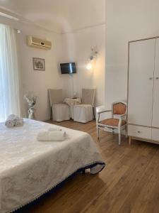 a bedroom with a bed and a tv and a chair at La Zagara B&B Centro Catania Vicino Duomo in Catania