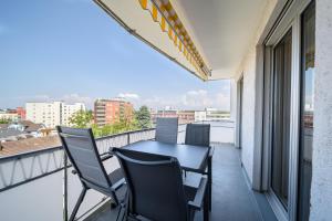 un balcone con tavolo e sedie su un edificio di Cooldis 4 !Gratis Parken, Free Parking! a Kreuzlingen