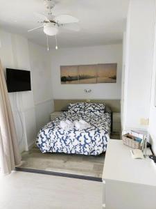 1 dormitorio con 1 cama y ventilador de techo en Frontal Ocean View Torres del Sol, en Los Cristianos