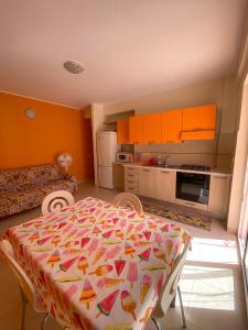 a kitchen with a table and a kitchen with orange walls at Villanna in Sperlonga