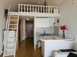 - une petite cuisine avec des lits superposés dans une chambre dans l'établissement Le Bellevue YourHostHelper, à Gruissan 3 autres photos