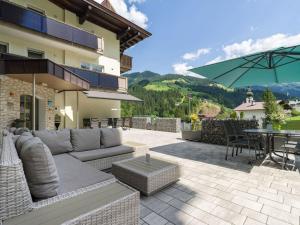a patio with a couch and a table and an umbrella at Sun Valley - Wildschönau in Auffach