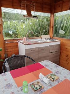 a kitchen with a table and a sink and a counter at Cabaña Los Linos in Guasca