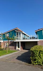 a house with a balcony on top of it at Friese Kust Villa in Workum