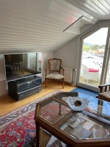 een woonkamer met een tv en een glazen tafel bij Tallgatan Fjällbacka in Fjällbacka