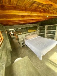 um quarto com uma cama e um tecto de madeira em Hermanos Perdidos Surf em Las Tunas