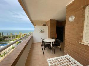 a balcony with a table and chairs and the ocean at Costa Marina III - 1ª línea de playa in El Borseral +40 photos