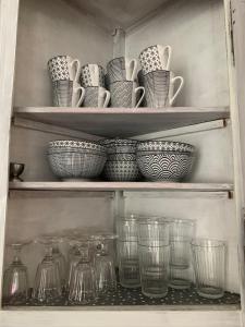 a shelf filled with glasses and bowls and plates at Haus Finchen - Alte Näherei in Hückelhoven