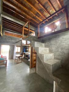 uma sala de estar com uma escada numa casa em Hermanos Perdidos Surf em Las Tunas
