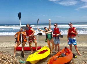 a group of people standing on the beach with kayaks at Hermanos Perdidos Surf in Las Tunas