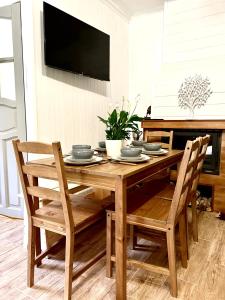 a wooden dining room table with chairs and a television at Siedlisko Nad Potokiem in Hołuczków